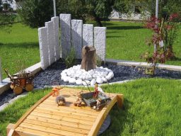 Splittbeet mit Marmor Kies und umrahmt von Palisaden