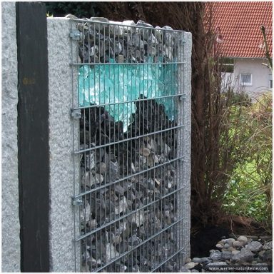 Gabione mit dunklen Steinen und Glas